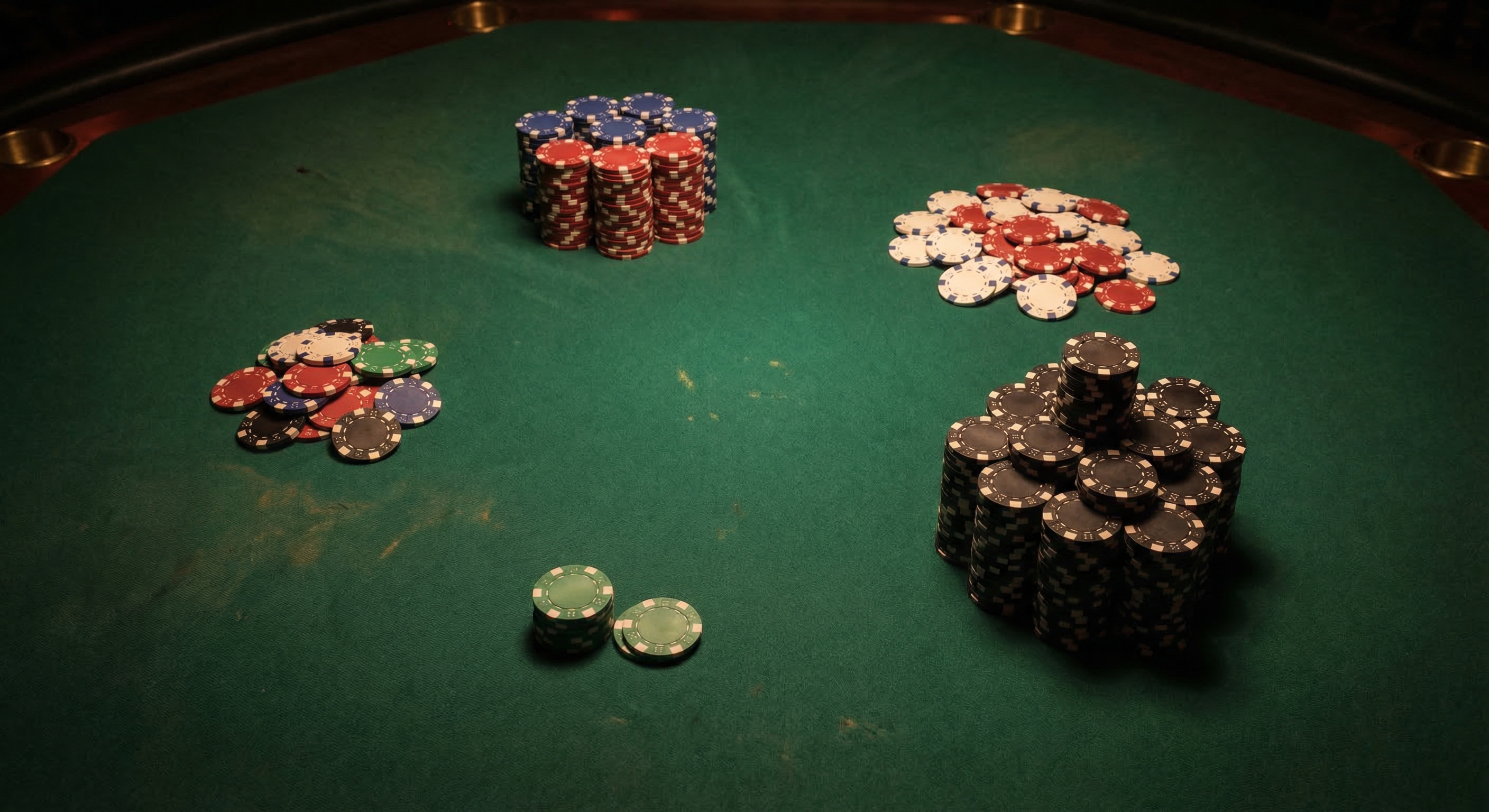 Five distinct chip stacks on a green poker felt under moody casino lighting, representing different poker player archetypes